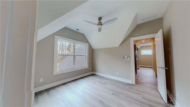 bonus room featuring lofted ceiling, ceiling fan, a healthy amount of sunlight, and light hardwood / wood-style flooring