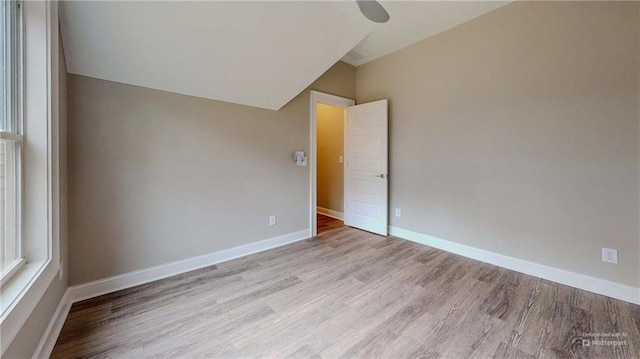 empty room featuring lofted ceiling and light hardwood / wood-style floors