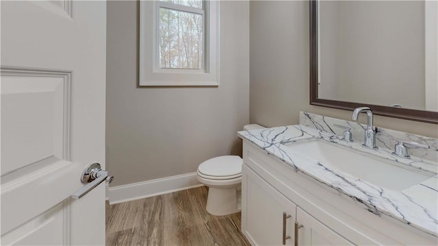 bathroom with hardwood / wood-style floors, toilet, and vanity