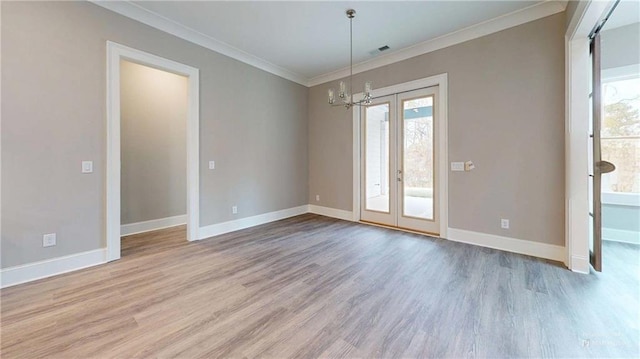 unfurnished room with an inviting chandelier, ornamental molding, and light hardwood / wood-style flooring