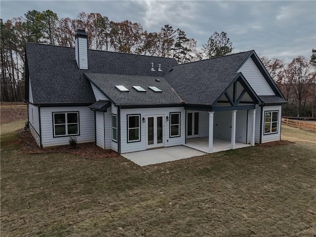 back of property with a patio area, a lawn, and french doors