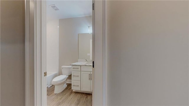 full bathroom featuring toilet, vanity, shower / washtub combination, and hardwood / wood-style floors