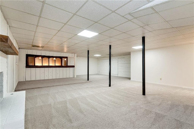 basement with a paneled ceiling and carpet flooring