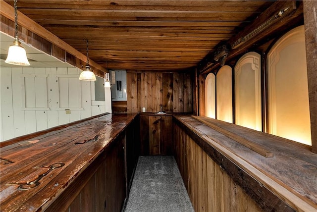 bar with butcher block countertops, wood walls, electric panel, dark carpet, and wood ceiling