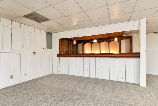 basement with carpet floors, a drop ceiling, and electric panel