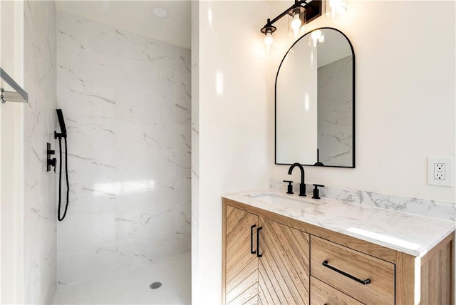 bathroom with vanity and a tile shower