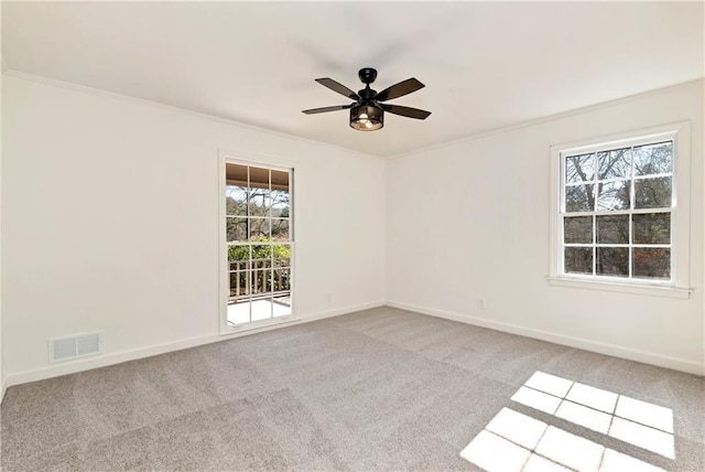 carpeted spare room featuring crown molding and ceiling fan