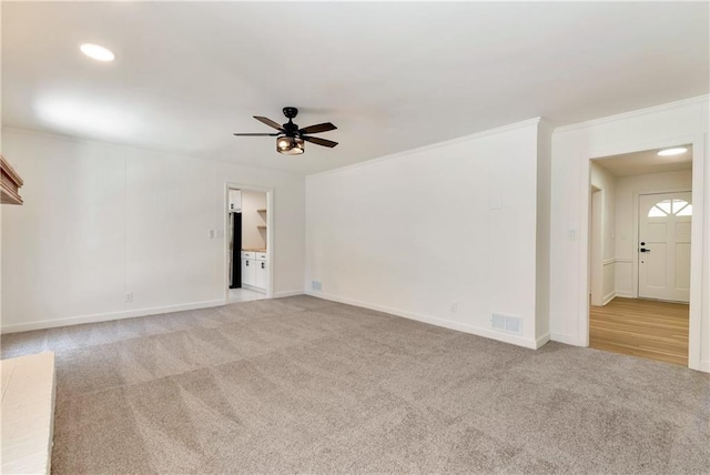 carpeted spare room featuring ornamental molding and ceiling fan