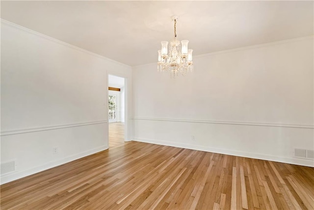 unfurnished room featuring crown molding, a chandelier, and light hardwood / wood-style flooring