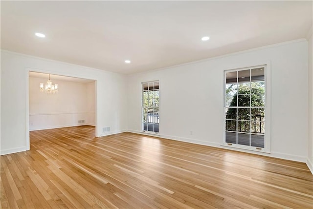 unfurnished room with ornamental molding, light hardwood / wood-style floors, and a notable chandelier