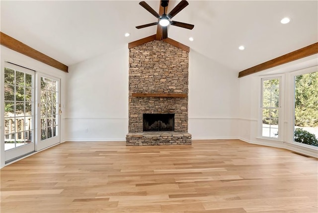 unfurnished living room with a stone fireplace, a wealth of natural light, beam ceiling, and light hardwood / wood-style flooring