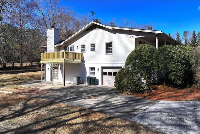 back of house with central AC, a garage, and a deck