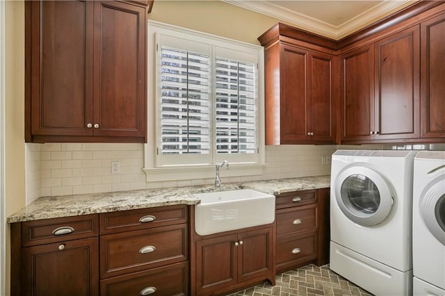 clothes washing area with crown molding, cabinets, separate washer and dryer, and sink