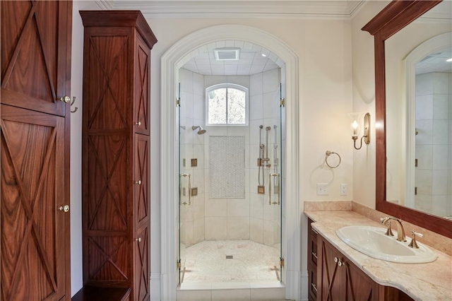 bathroom featuring ornamental molding, vanity, and a shower with shower door