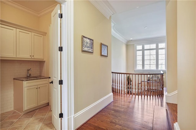 hallway featuring sink, light hardwood / wood-style flooring, and ornamental molding