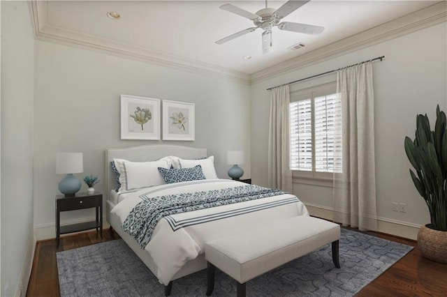 bedroom with dark hardwood / wood-style flooring, ceiling fan, and crown molding