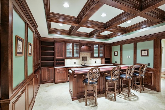 bar with beamed ceiling, ornamental molding, sink, and coffered ceiling