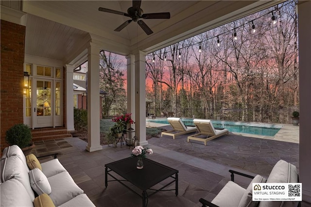 patio terrace at dusk featuring an outdoor living space and ceiling fan