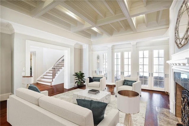 living room featuring french doors, ornamental molding, coffered ceiling, a premium fireplace, and beamed ceiling