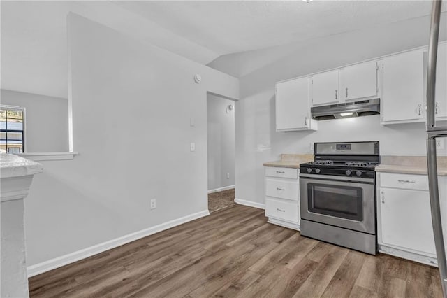 2044 Teal Cv, Lithonia, GA 30058 - kitchen featuring stainless steel gas range oven, light countertops, wood finished floors, lofted ceiling, and under cabinet range hood