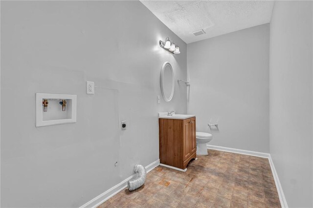 2044 Teal Cv, Lithonia, GA 30058 - bathroom featuring vanity, toilet, a textured ceiling, baseboards, and visible vents