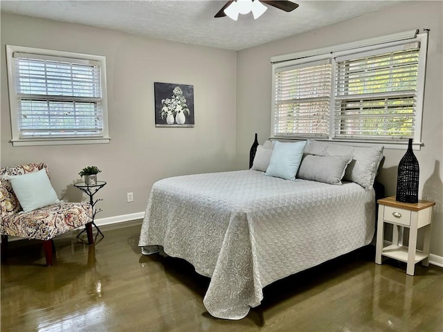 bedroom featuring ceiling fan, multiple windows, a textured ceiling, and wood-type flooring