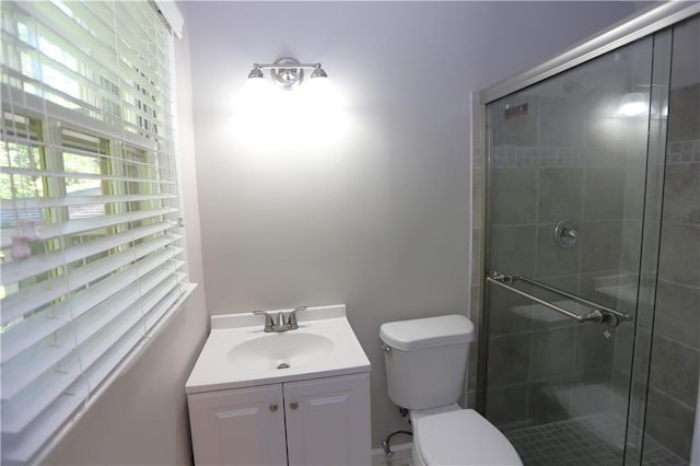 bathroom with toilet, vanity, and a shower with door