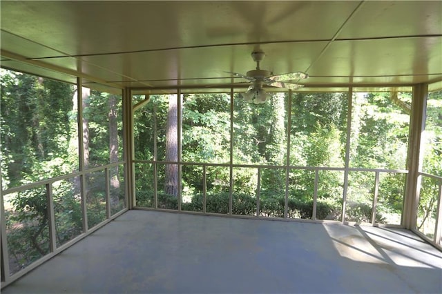 unfurnished sunroom featuring a healthy amount of sunlight and ceiling fan