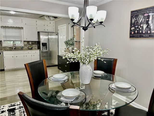 dining room featuring ceiling fan with notable chandelier, sink, light hardwood / wood-style flooring, and crown molding