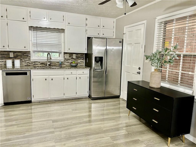 kitchen with stainless steel appliances, white cabinets, and sink