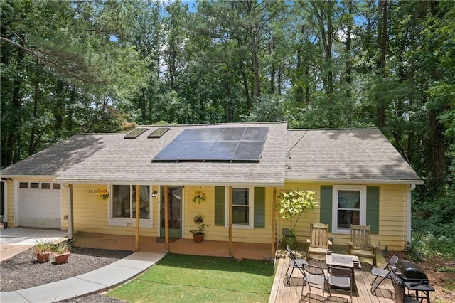 single story home featuring solar panels and a garage