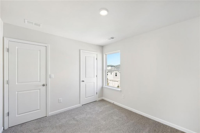 unfurnished room featuring light colored carpet