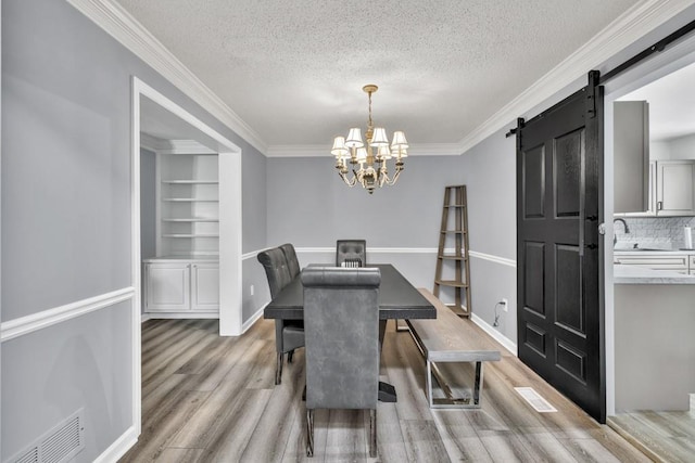 3910 Meeting St, Duluth, GA 30096 - dining area with crown molding, light wood finished floors, a textured ceiling, a chandelier, and a barn door