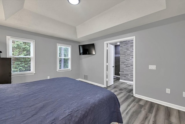 3910 Meeting St, Duluth, GA 30096 - bedroom featuring wood finished floors, baseboards, a tray ceiling, and ensuite bath