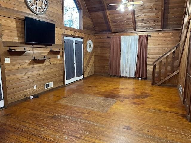 interior space featuring beamed ceiling, wood-type flooring, wooden ceiling, and wood walls