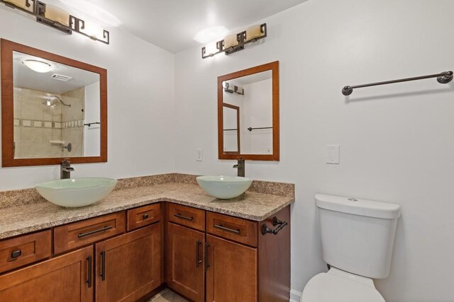 3334 Peachtree Rd NE Unit 101, Atlanta, GA 30326 - full bath featuring toilet, a tile shower, and double vanity