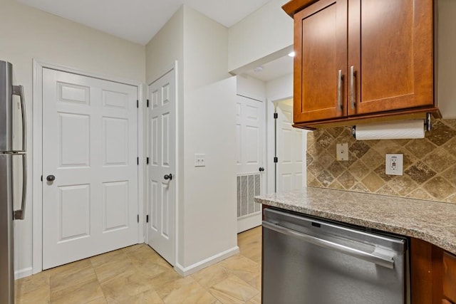 3334 Peachtree Rd NE Unit 101, Atlanta, GA 30326 - kitchen with stainless steel appliances, tasteful backsplash, brown cabinets, and baseboards
