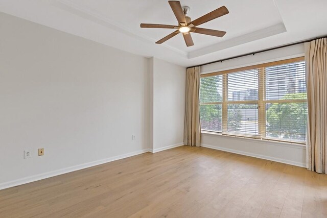 3334 Peachtree Rd NE Unit 101, Atlanta, GA 30326 - empty room with a raised ceiling, a ceiling fan, light wood finished floors, and baseboards