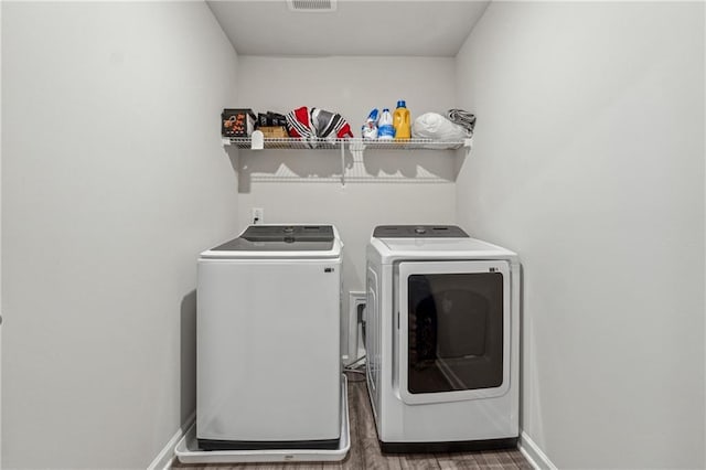 washroom with dark hardwood / wood-style flooring and separate washer and dryer