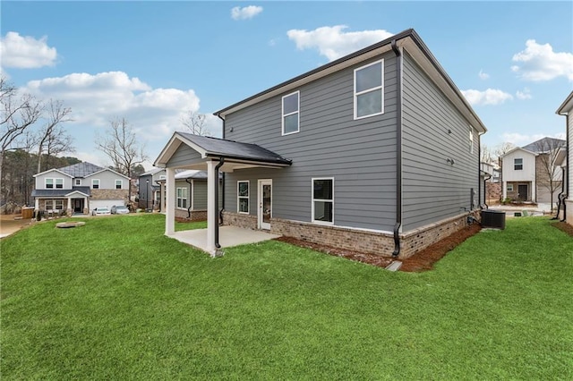 back of house featuring central air condition unit, a patio area, and a lawn