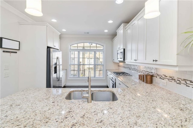 kitchen with sink, white cabinets, backsplash, stainless steel appliances, and light stone countertops