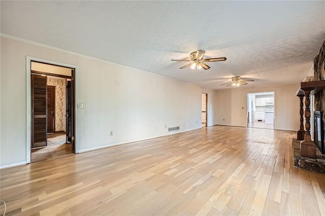 unfurnished living room with ceiling fan, light hardwood / wood-style floors, and a textured ceiling