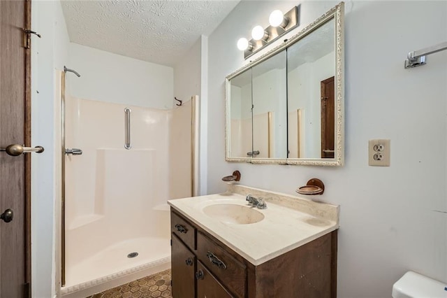 bathroom featuring vanity, toilet, a textured ceiling, and walk in shower