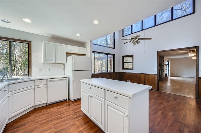 kitchen with dark hardwood / wood-style flooring, ceiling fan, white cabinets, and white appliances