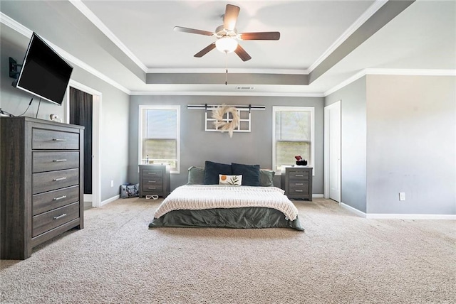 carpeted bedroom featuring a raised ceiling, baseboards, crown molding, and a ceiling fan
