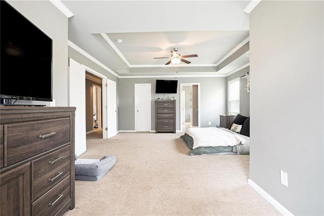 carpeted bedroom with a tray ceiling, ornamental molding, baseboards, and ceiling fan