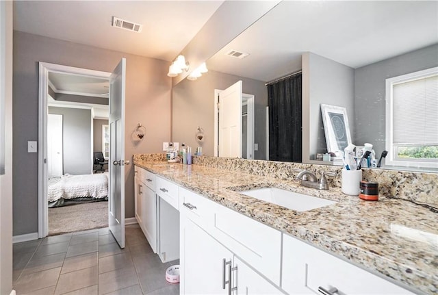 bathroom featuring tile patterned flooring, vanity, baseboards, and ensuite bathroom