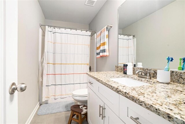 full bathroom featuring toilet, vanity, tile patterned flooring, baseboards, and shower / tub combo