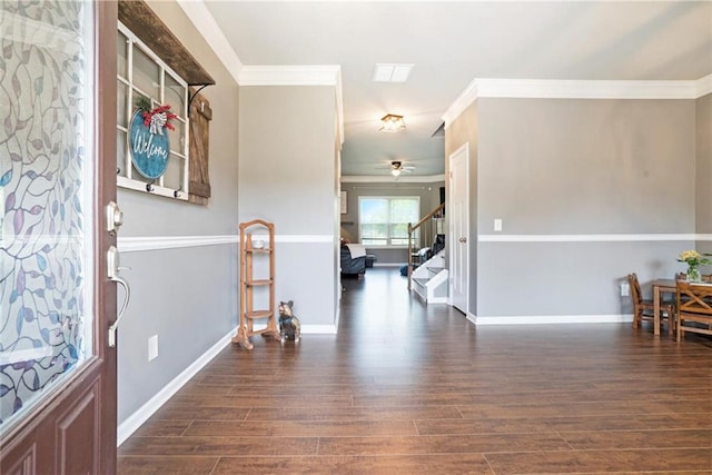 foyer featuring wood finished floors, crown molding, stairway, ceiling fan, and baseboards