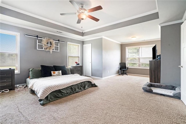bedroom featuring carpet, a tray ceiling, baseboards, ornamental molding, and ceiling fan